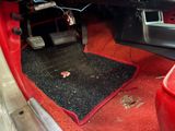 a close up of a car ' s interior with a red carpet