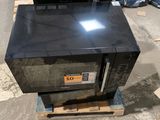 a microwave sitting on top of a pallet in a warehouse