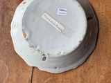 a white plate on a wooden table with a tag on it