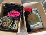 deux cartons remplis de vêtements, ainsi que des vêtements posés à même le sol