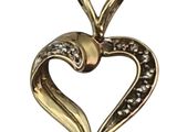 a close up of a heart shaped pendant on a white background