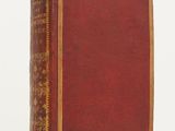 un vieux livre à la couverture rouge et à la bordure dorée