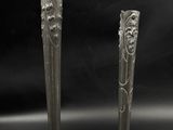 two silver vases sitting next to each other on a table