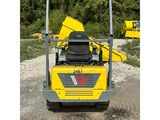 an image of a yellow construction vehicle parked on a gravel lot