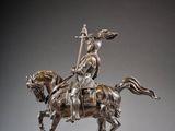 statue of a man on a horse with a spear on a wooden base