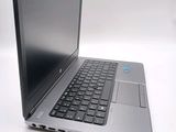 a silver laptop with a black keyboard on a white surface