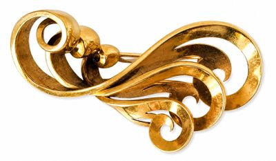 an image of a gold brooch with swirls on a white background