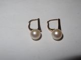 pair of pearl earrings on white surface with white background