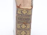 an old book sitting on top of a white surface