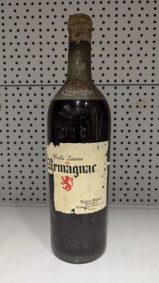 une vieille bouteille de vin posée sur un plan de travail blanc