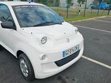 une petite voiture blanche garée dans un parking