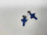 a pair of blue cross charms on a white surface