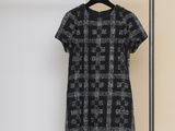 une robe noire et blanche suspendue à un portant dans une pièce
