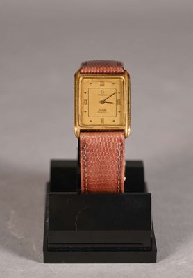 an image of a gold and pink watch on a black stand