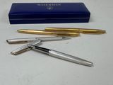 two fountain pens and a box on a table