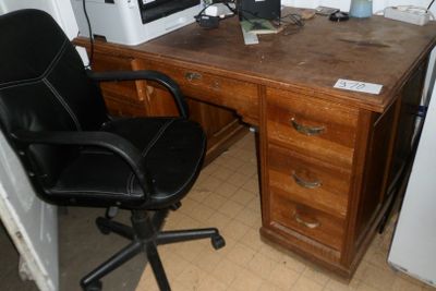 a desk with a computer and a chair in the corner