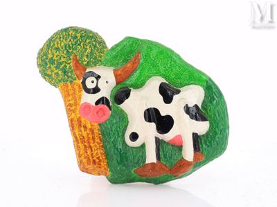 une figurine représentant une vache et un arbre sur un fond blanc