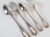 four silver spoons and a fork on a white surface