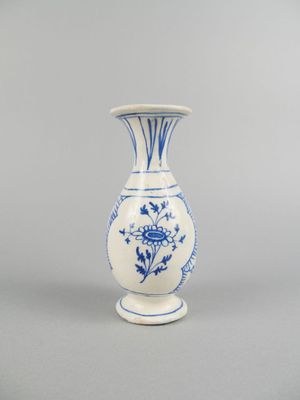 blue and white vase with a flower design on the bottom