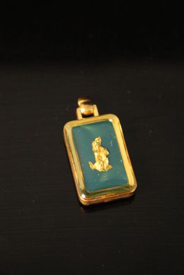a close up of a gold pendant with a picture of a woman on it