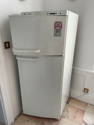 a white refrigerator in the corner of a room
