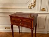 a small table with two drawers on it in a room