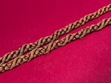 a close up of a gold chain on a pink background