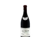 the bottle of red wine is sitting on a white surface