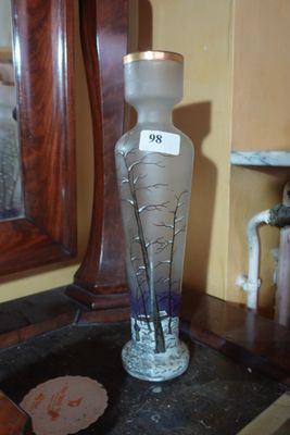 a glass vase sitting on top of a table next to a mirror