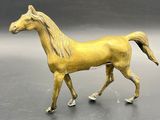 statue of a golden horse on a gray surface