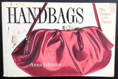 une image représentant un livre sur lequel est posé un sac à main rouge