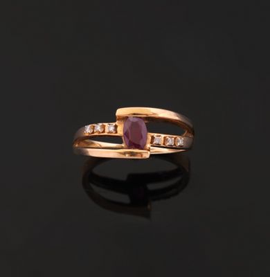 a close up of a gold ring with a ruby stone and diamonds