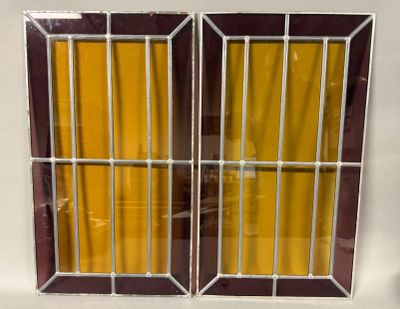 two windows with bars on each of them and a yellow curtain behind them