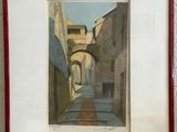 painting of a narrow street in a city with a red frame on the wall