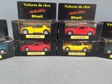 six different models of toy cars are in boxes on a table