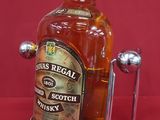 a bottle of whisky on a metal stand on a red background