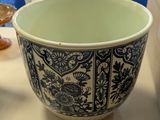 a blue and white bowl sitting on a table next to a teapot