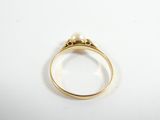 a close up of a gold ring with a pearl in the middle