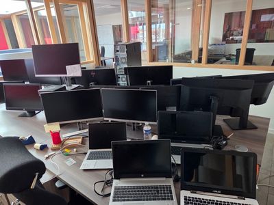 many laptops sitting on a table in a room