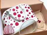 a white purse in a box with red polka dots on it
