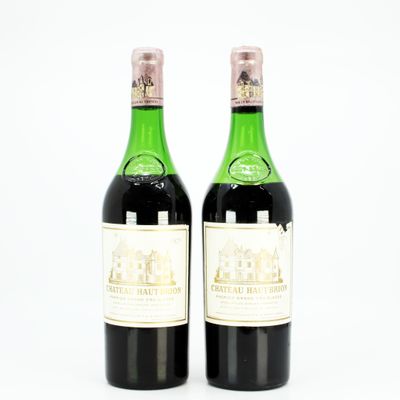 two bottles of wine sitting next to each other on a white surface