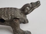 a small statue of a turtle on a white surface