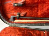 a violin in a case with a wooden stick in it