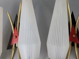 three white and gold wall sconces mounted on a white wall