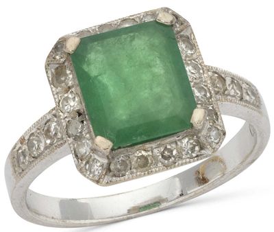 an emerald and diamond ring on a white background