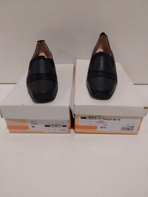 Deux paires de chaussures noires sont posées sur une boîte.