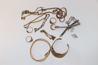 beaucoup de bijoux en or et en argent sur une surface blanche