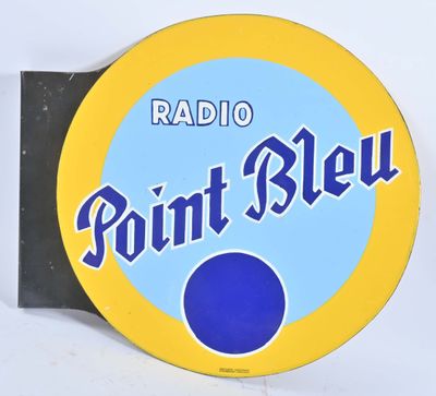 enseigne « Radio Point Bleu » sur un mur blanc, avec un point bleu