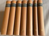 six livres à la couverture marron posés sur un drap blanc