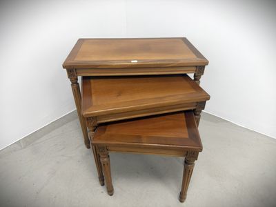 three wooden nesting tables stacked on top of each other in a room